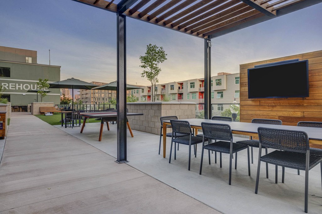 a patio with tables and chairs and a tv
