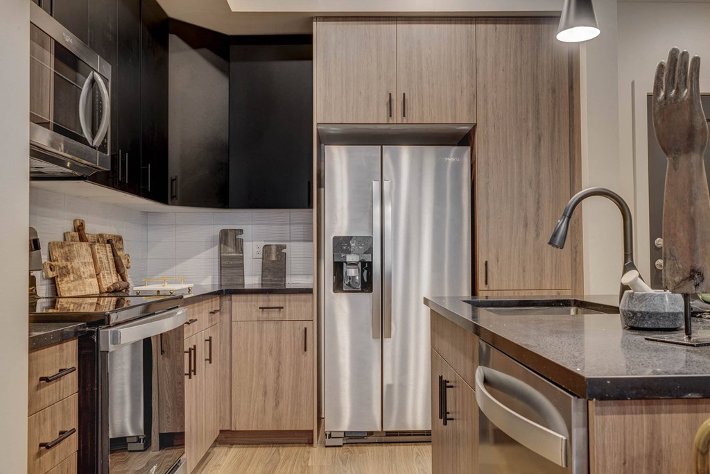 a kitchen with wooden cabinets and a stainless steel refrigerator
