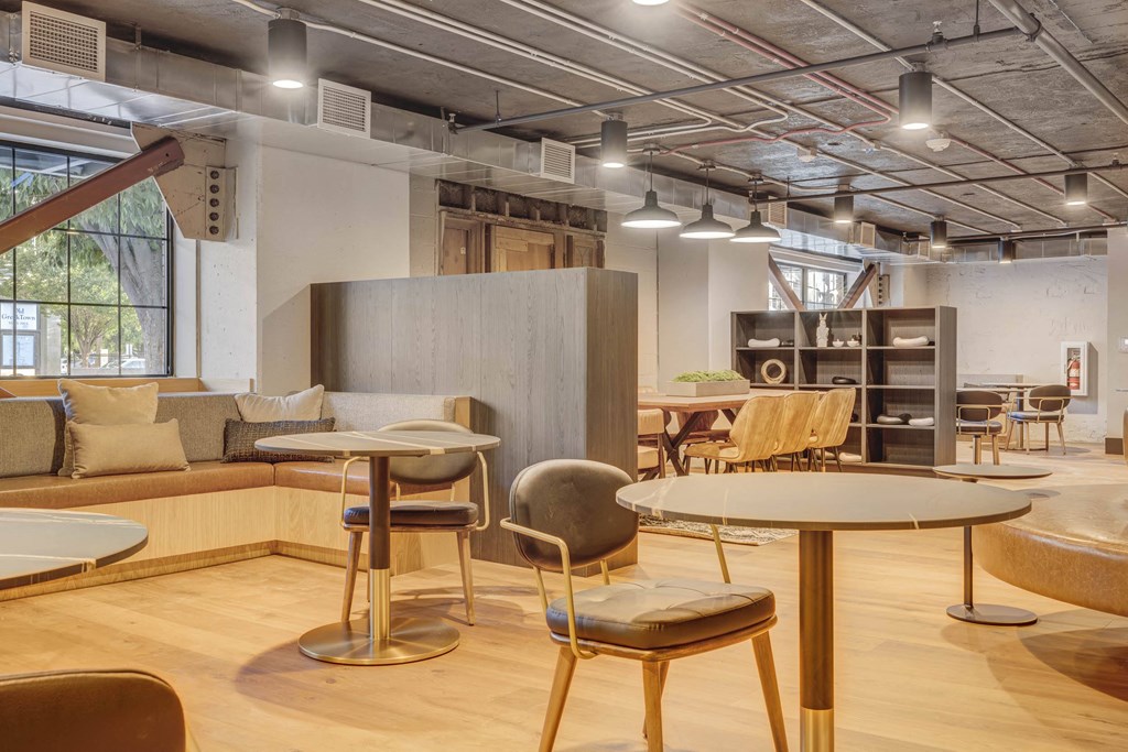 a seating area with tables and chairs in a lobby