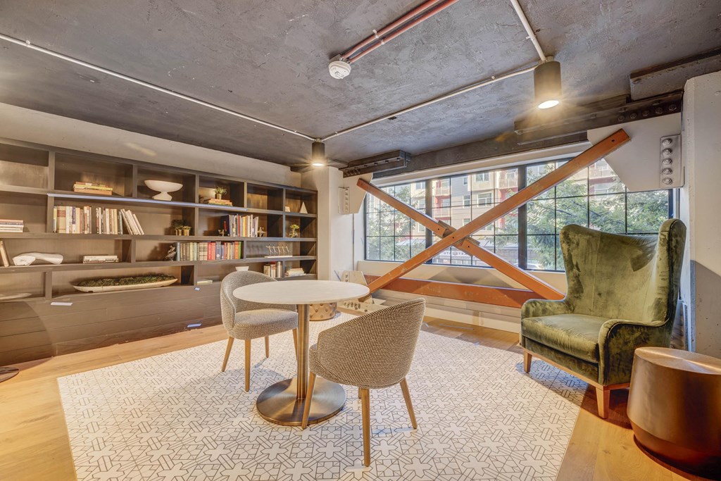 a living room with a green chair and table and a large window