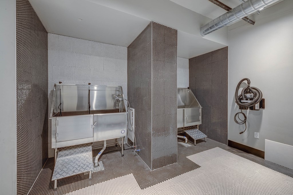 a bathroom with two stainless steel sinks and a urinal