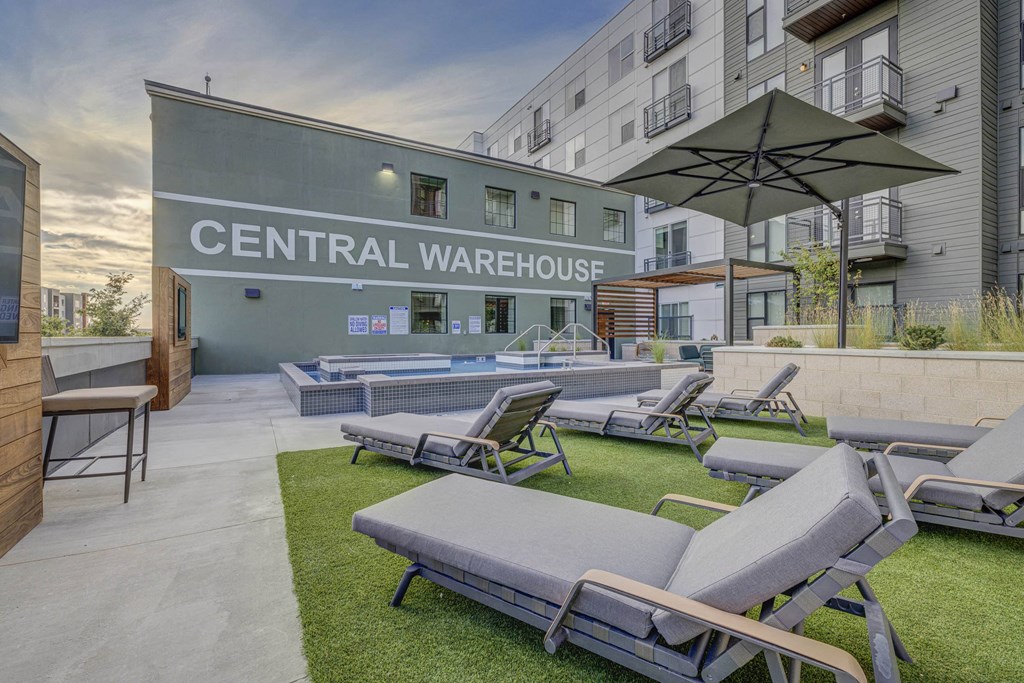 furnished patio with lounge chairs and umbrellas at the central warehouse apartments