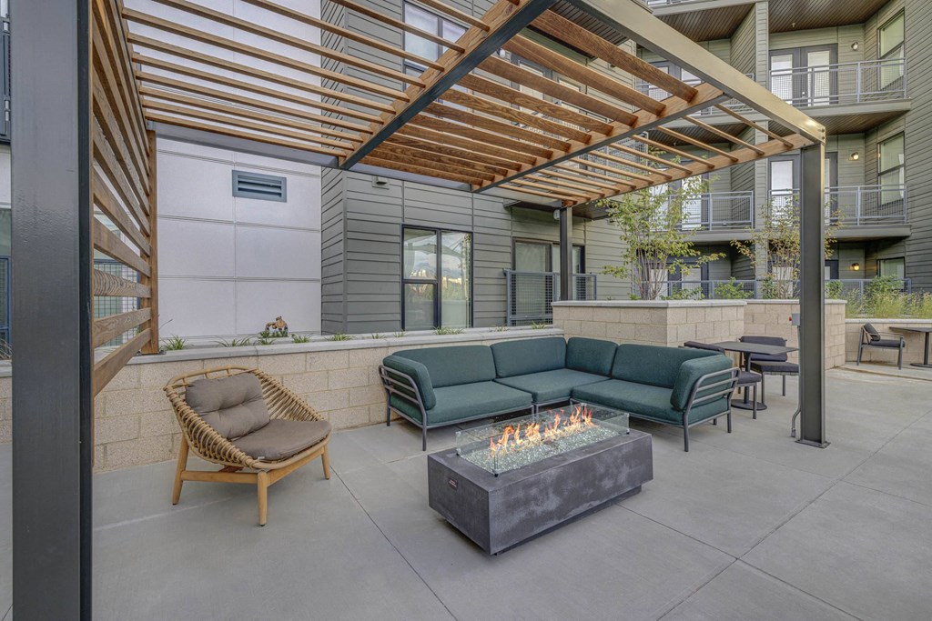 a patio with couches and chairs and a fire pit
