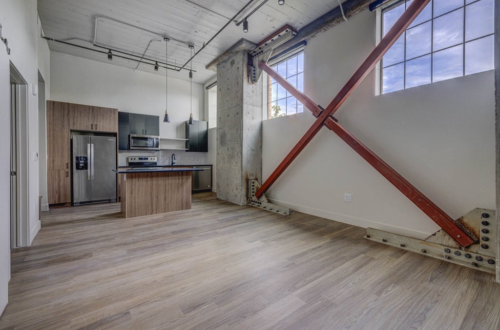 an open kitchen and living room with a large red x on the wall