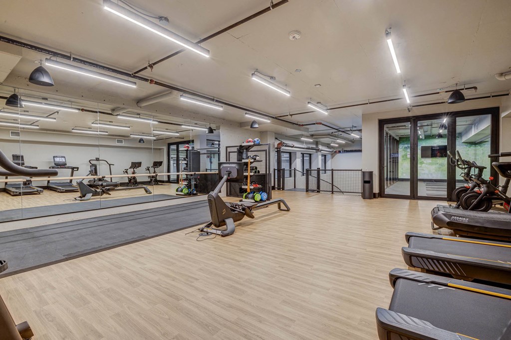 a gym with weights and yoga mats and a reformer