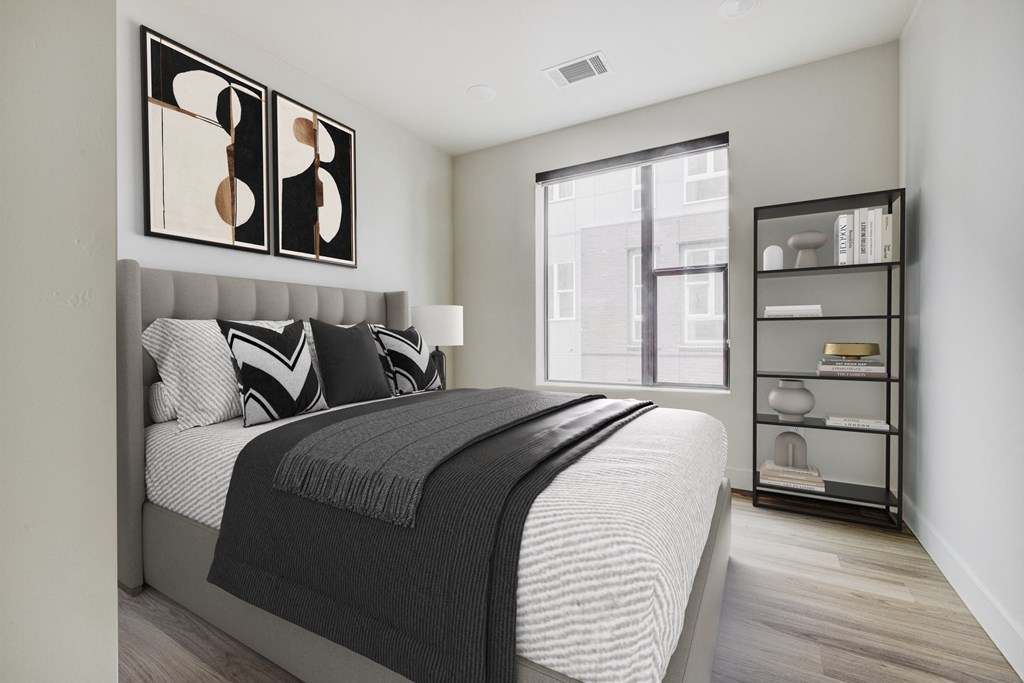 an apartment bedroom with a bed and a window