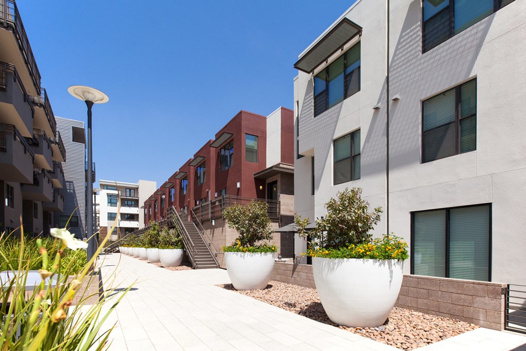a row of apartment buildings with large planters in front of them