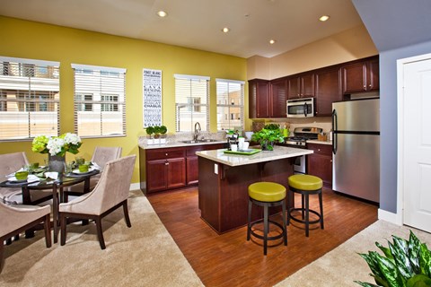 A kitchen with a table and chairs in front of a window.