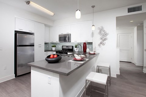 a kitchen with a large island and a stainless steel refrigerator