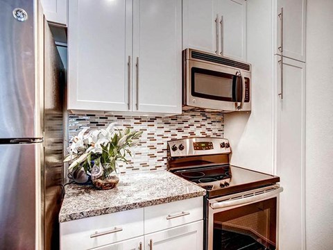 a kitchen with white cabinets and a stove and a microwave