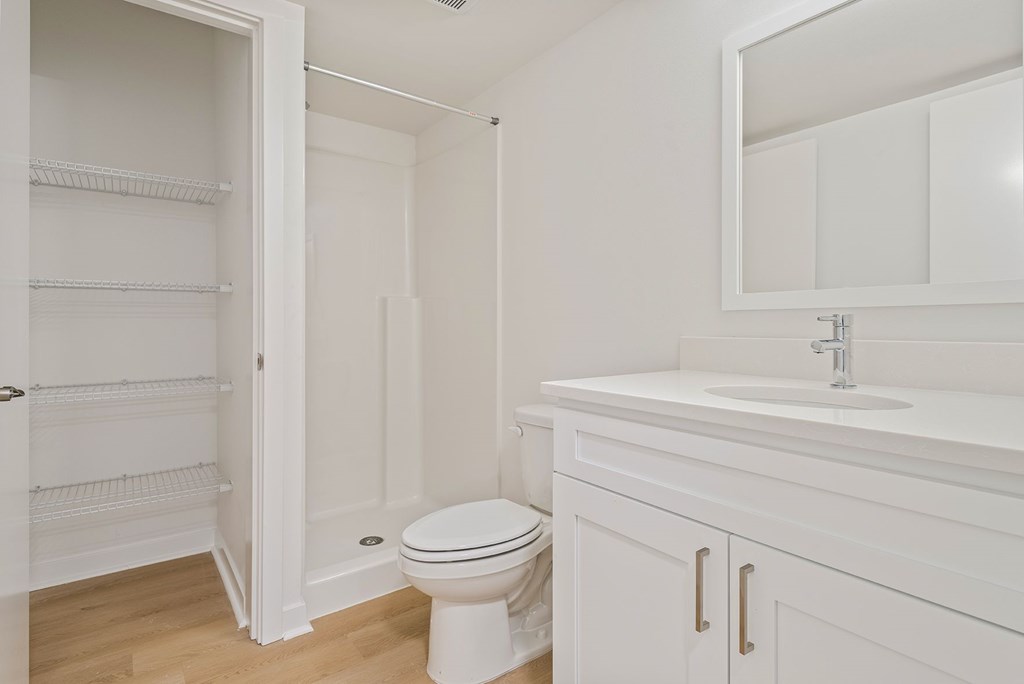 A white bathroom with a toilet, sink, and medicine cabinet.