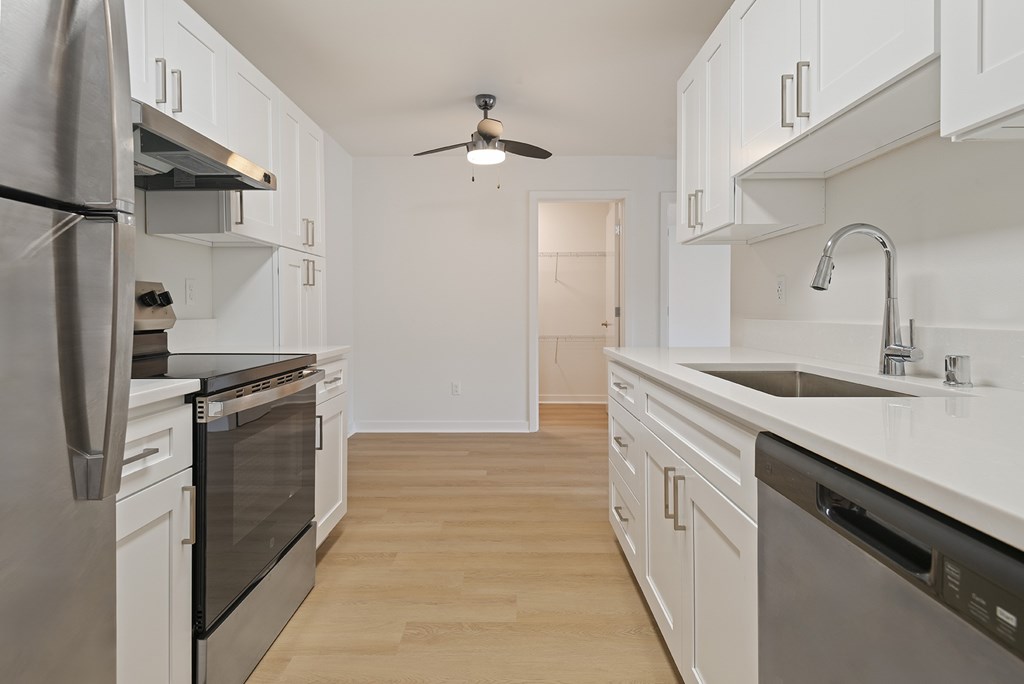 A kitchen with white cabinets and stainless steel appliances.