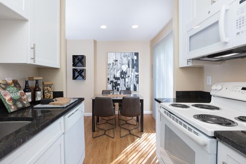 a kitchen with white appliances and a table with chairs