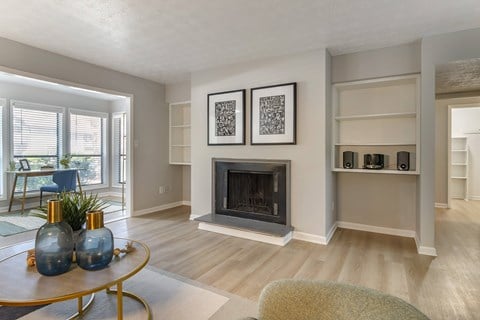 A living room with a fireplace and a painting on the wall.
