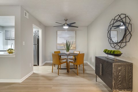 A dining room with a wooden table and chairs.