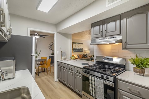 A kitchen with a stove top oven and a refrigerator.