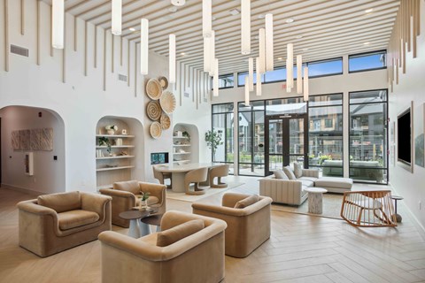 a living room with couches and chairs and large windows