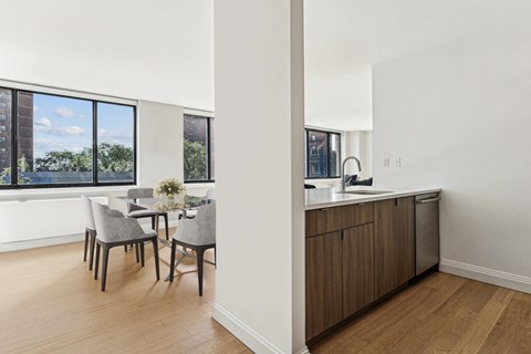 an open kitchen and dining area with a large window and a table and chairs