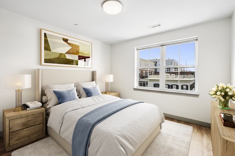 A bedroom with a large bed and a painting on the wall.