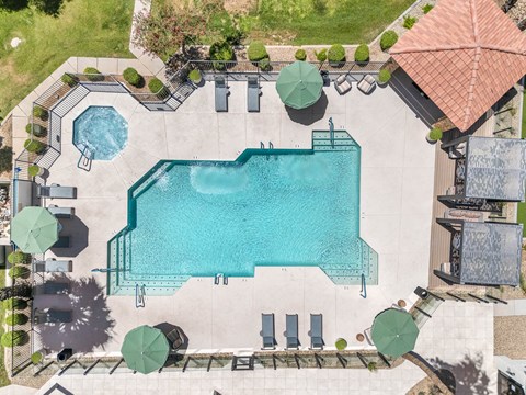 An aerial view of a swimming pool surrounded by a patio area.