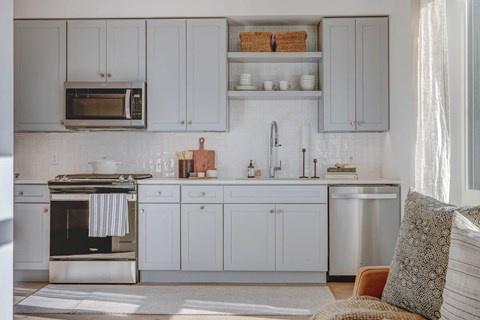 a kitchen with white cabinets and a stove and a microwave