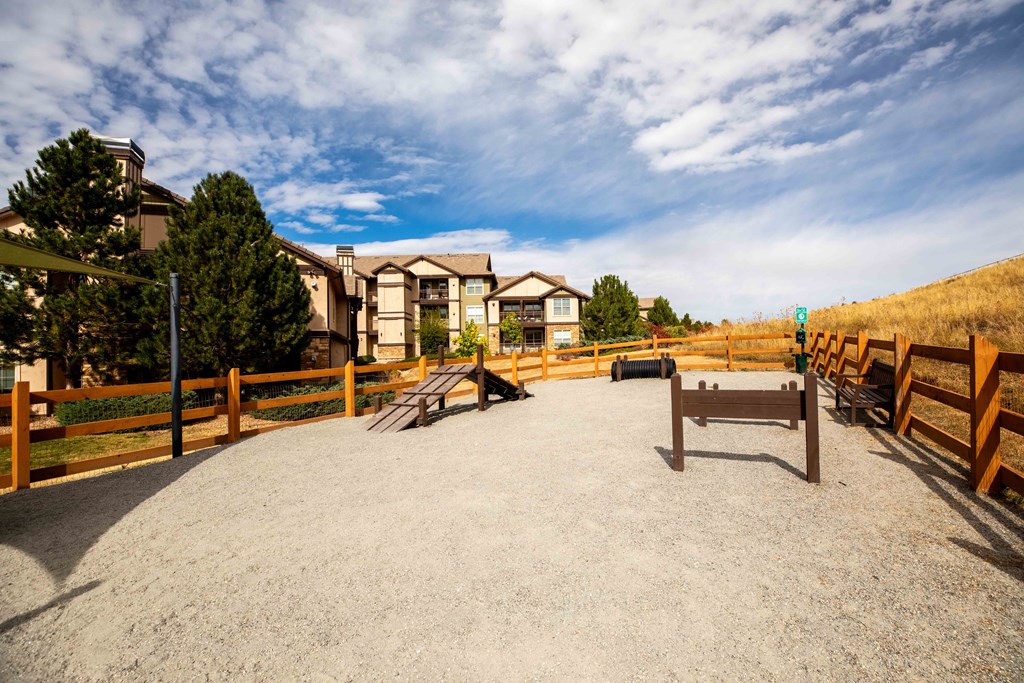 a fire pit with a bench in front of some buildings
