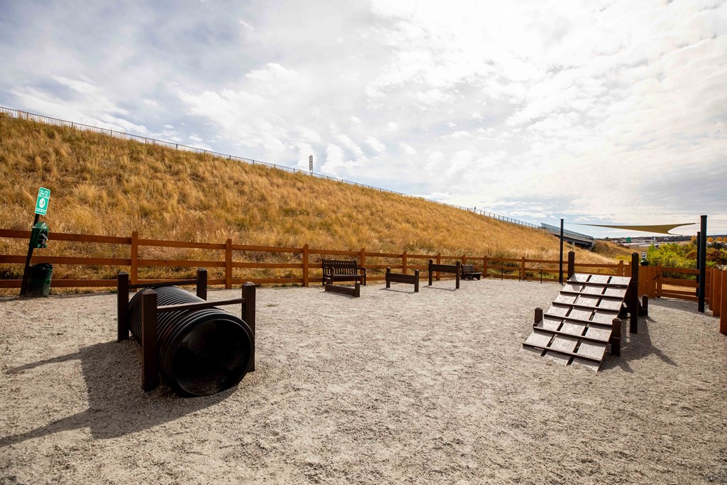 a group of benches in a sandy area next to a hill