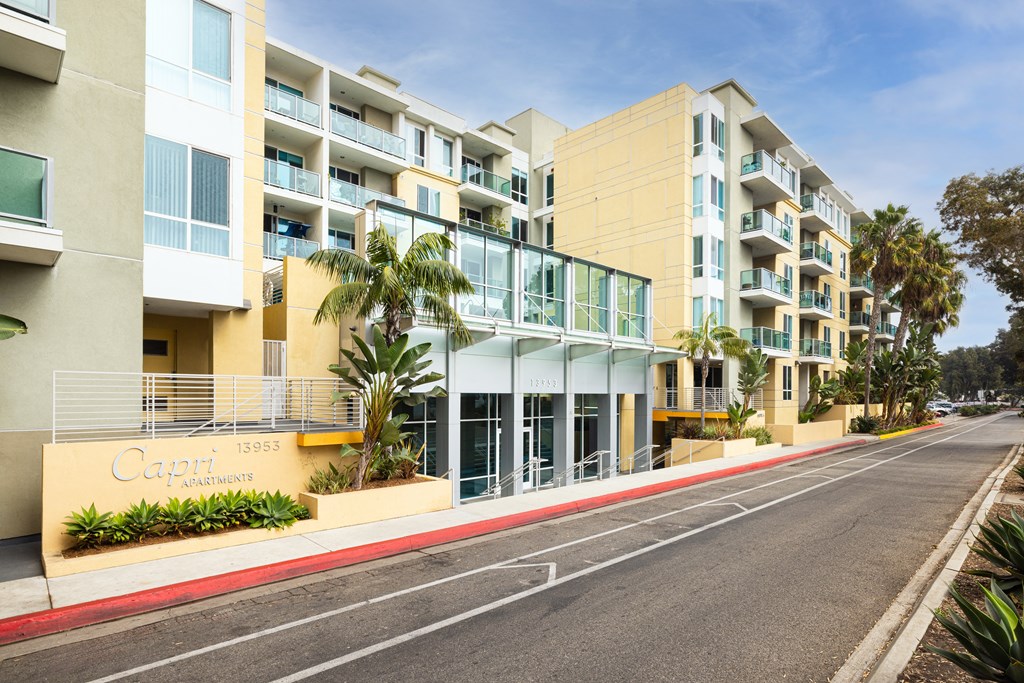 A street view of a Cayman Apartments building with a clear blue sky above.