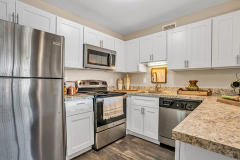 A kitchen with white cabinets and stainless steel appliances.