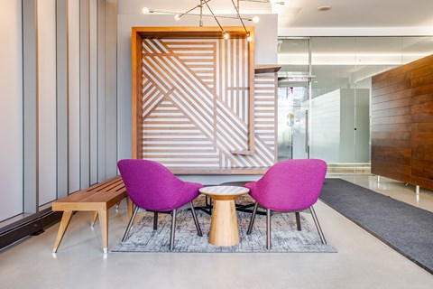 A modern living room with a purple chair and a wooden bench.
