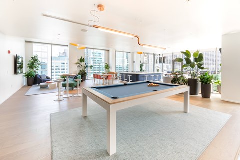 A pool table in a room with a view of the city.