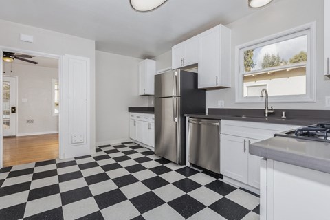 a kitchen with a checkered floor and a stainless steel refrigerator