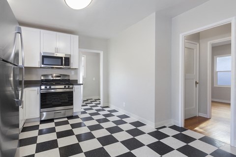 a kitchen with a checkered floor and stainless steel appliances