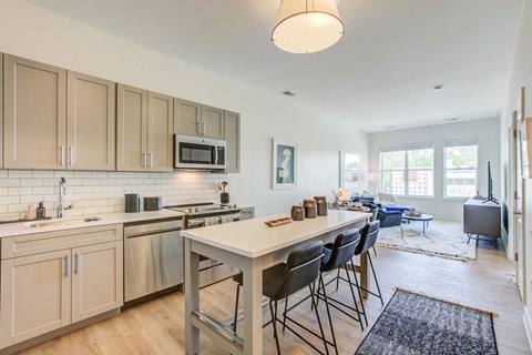 a kitchen with a long counter and a table with chairs