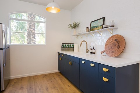 a blue and white kitchen with a sink and a window