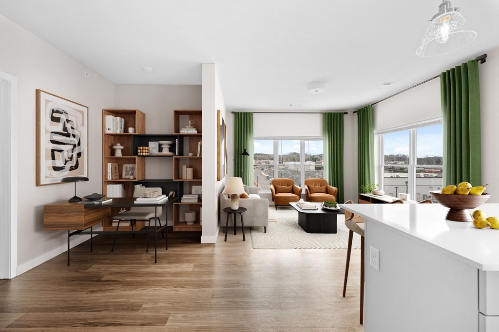 a living room and dining room with a kitchen and a large window