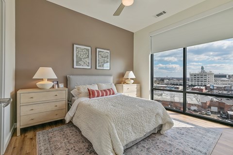 A bedroom with a large bed and a view of the city.