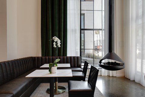 A modern dining room with a black booth and a white table.