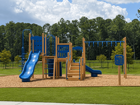A playground with a blue slide and wooden structure.