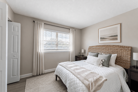 A bedroom with a large bed and a painting on the wall.