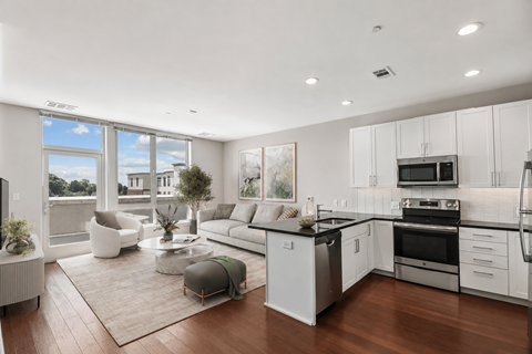 A modern kitchen with white cabinets and stainless steel appliances.