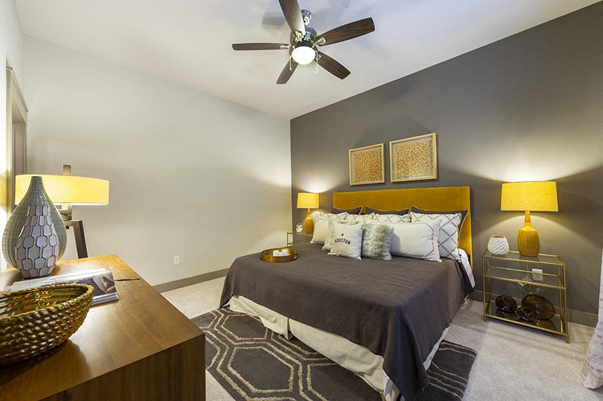 a bedroom with a large bed and a ceiling fan