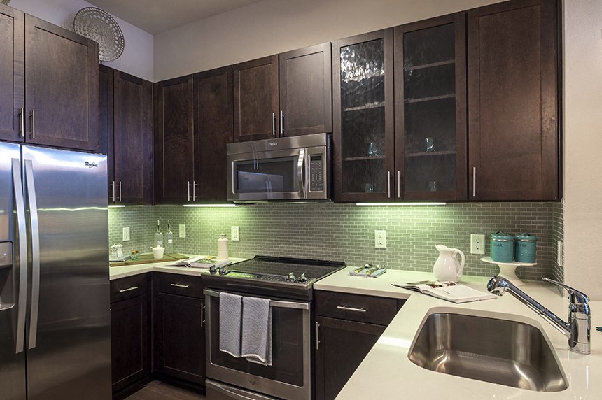 a kitchen with stainless steel appliances and dark wood cabinets