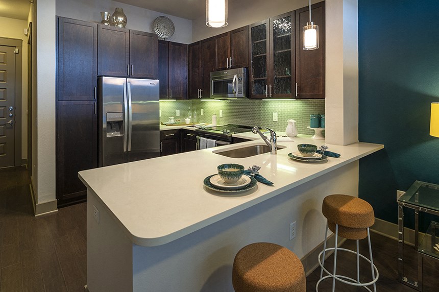 a kitchen with a large island and stainless steel appliances