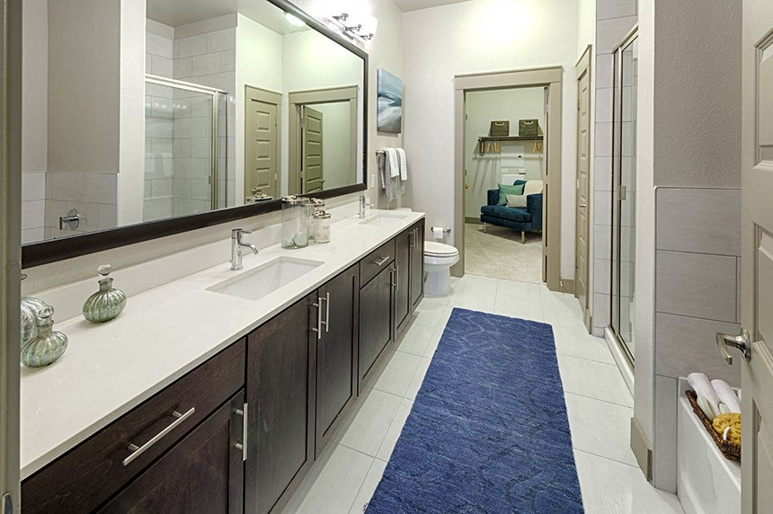 a large bathroom with two sinks and a blue rug