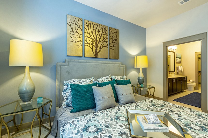 a bedroom with a bed and two paintings on the wall