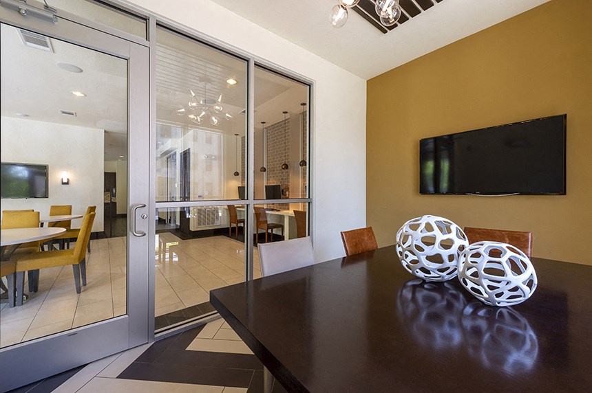 a dining room with a table and a tv on the wall