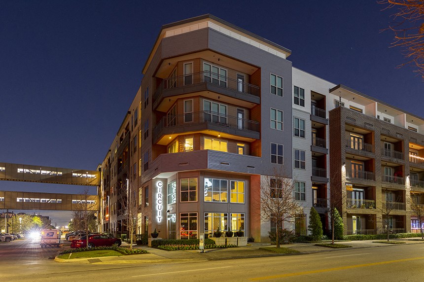 an apartment building on a city street at night