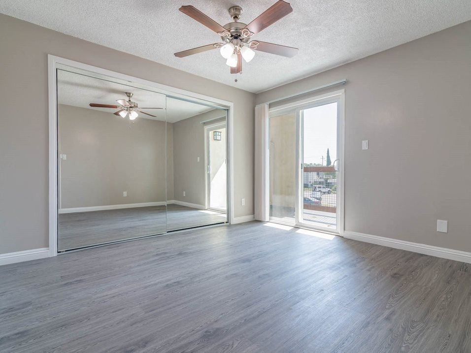 an empty room with a ceiling fan and a door at Citrus Court Apartments, Whittier, California
