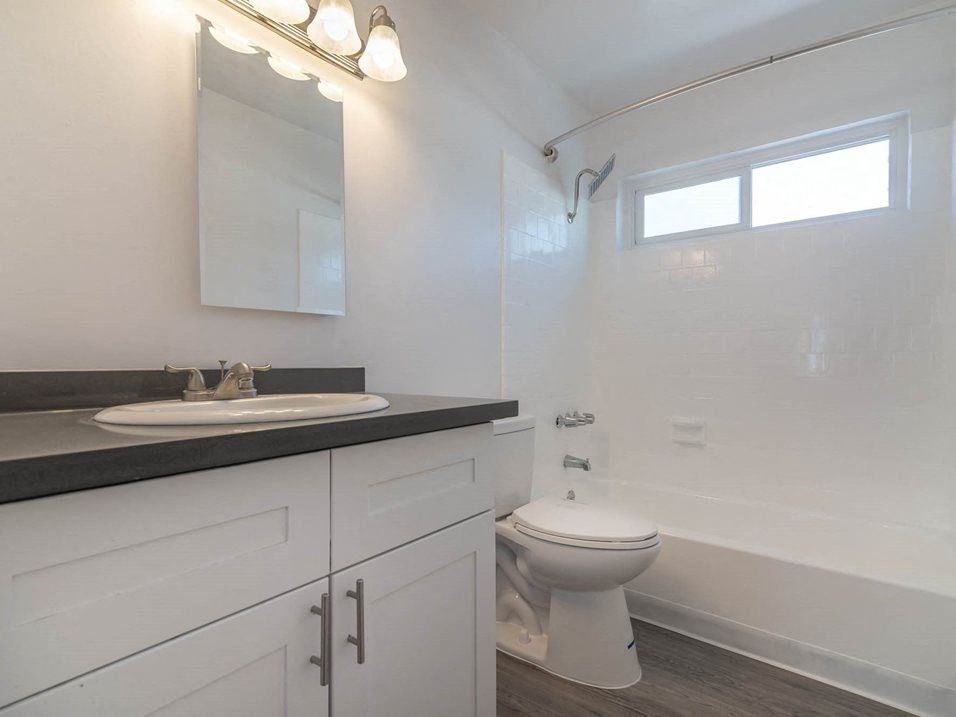 a bathroom with a toilet and a sink at Citrus Court Apartments, Whittier, CA